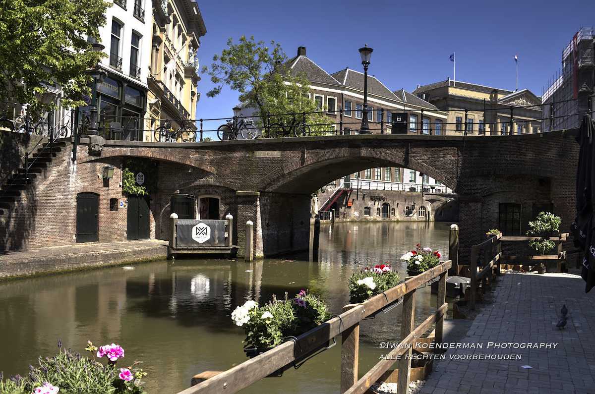 HDR-foto van de Oudegracht in Utrecht met de Winkel van Sinkel, historische brug en oude pakhuizen, genomen vanaf werfniveau.