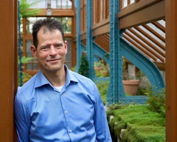 Iwan Koenderman in blauw shirt bij de Botanische Tuinen Utrecht, social media coach voor jouw groei
